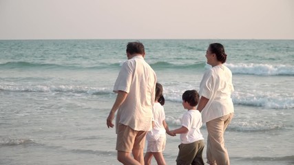 Wall Mural - 4K Happy Asian Grandparents and two grandchildren walking on the beach and having fun together with smiling at summer sunset. Asian family relaxing and enjoying lifestyle in travel holiday vacation.