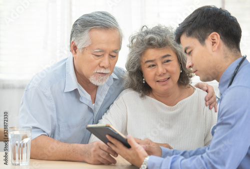 Fotomural Elder senior old asian couple meeting specialist professional caucasian doctor visit at home consultant two retirement patient after checkup,health care and medical concept