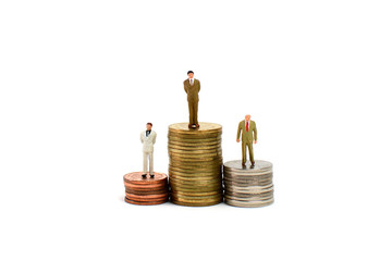 Miniature figures businessman on coins, on the white backgroud.