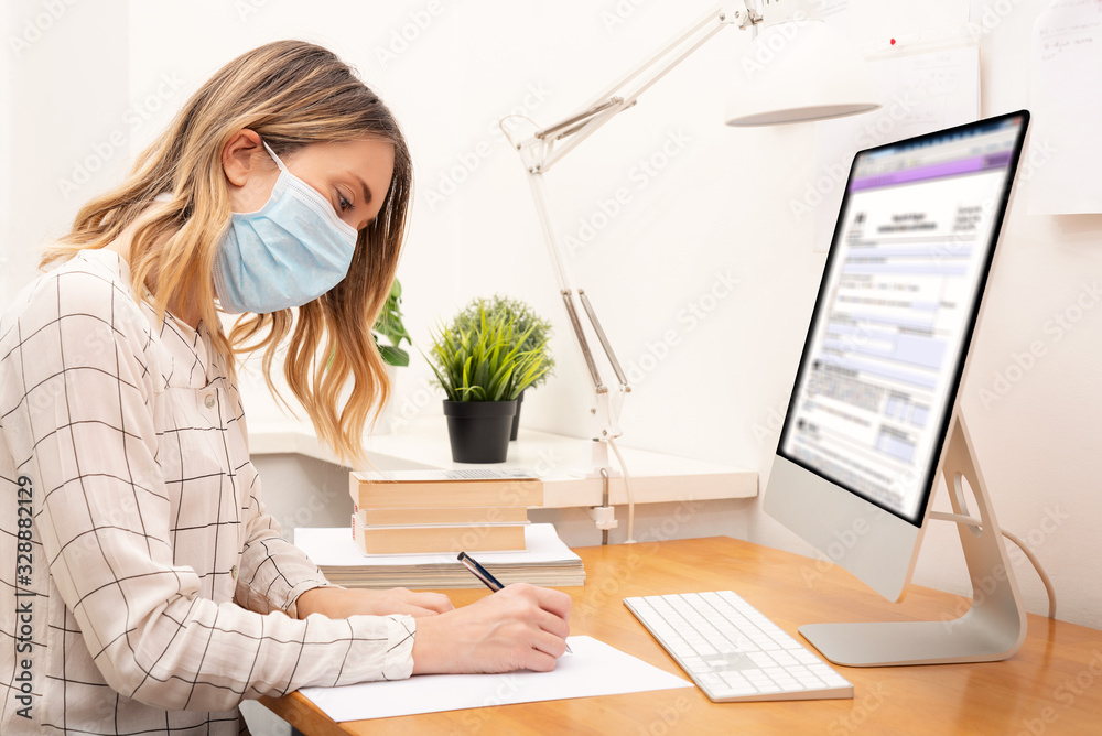 Young business woman working from home, wearing protective mask - obrazy, fototapety, plakaty 