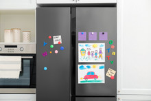 Modern Refrigerator With Child's Drawings, Notes And Magnets In Kitchen