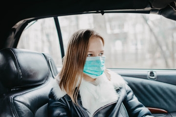 Young woman in a car in a medical mask, preventive measures for an epidemic.