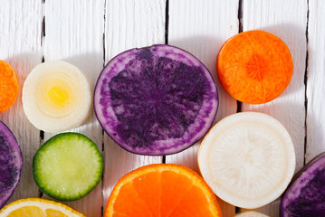 Canvas Print - sliced fruits and vegetables on white wood table background