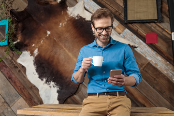 Wall Mural - Happy model laughing, holding coffee cup and phone