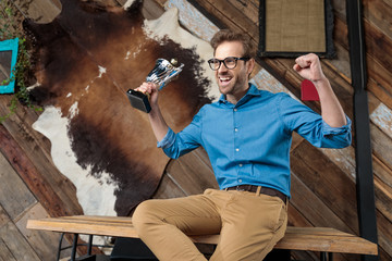 Wall Mural - Cheerful model shouting and celebrating, holding trophy