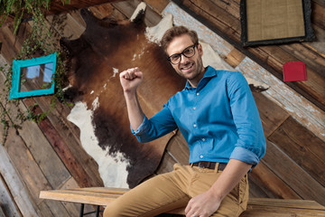 Wall Mural - Cheerful model celebrating with his fist in the air