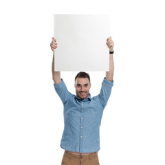 Proud casual man holding empty billboard above his head