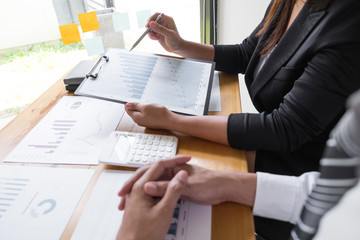 Two business people are discussing about business graph on the table in the office room