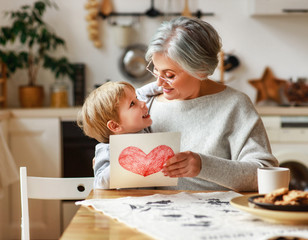 Sticker - happy family grandson child congratulates grandmother on holiday and gives card.