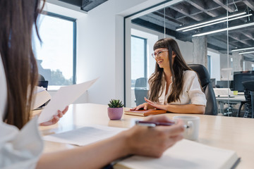 Wall Mural - Attractive young woman job applicant with a candid smile at a job interview for a new job post