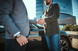 © Fxquadro - Photo of a two men shaking hands in front of a black car standing outdoors, wearing stylish clothes. Close up shoot