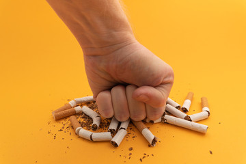 human hand crushed several cigarettes. concept of smoking cessation and healthy lifestyle