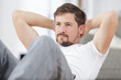 © auremar - young man doing abdominal crunches in the living room