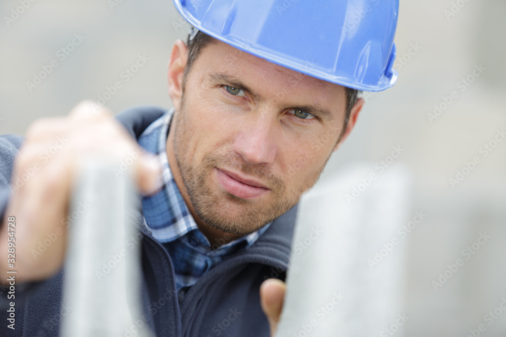 attractive and confident builder at a constructor site - obrazy, fototapety, plakaty 