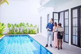 Fototapeta  - Woman showing pool of the new home to the couple