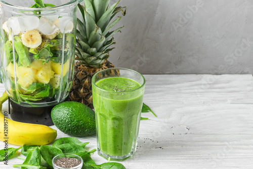 Cuadros en Lienzo Glass of green smoothie detox with fresh juicy ingredients in blender for making