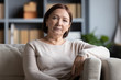 © fizkes - Head shot portrait peaceful tranquil middle aged old woman resting on cozy sofa alone at home. Pleasant happy senior mature 60s grandmother relaxing on couch in living room, posing for photo.