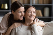 © fizkes - Head shot close up dreamy two generations women relaxing at home, looking aside. Young woman cuddling pleasant happy middle aged 60s mother, visualizing future, planning weekend leisure free time.