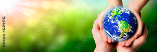 Fotografía Caring Hands Of Man And Woman Holding Earth - Earth Day / Care For The Environme