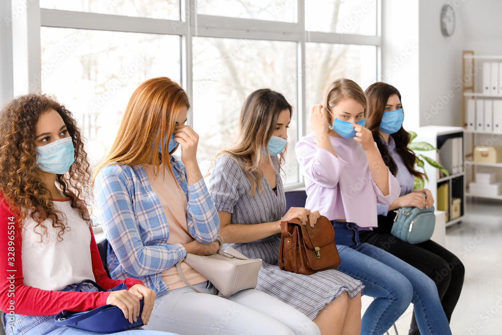 Patients with protective masks sitting in hall of clinic. Concept of epidemic