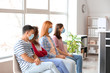© Pixel-Shot - Patients with protective masks sitting in hall of clinic. Concept of epidemic
