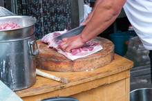 China, Heihe, July 2019:a Butcher Cuts Meat At A Street Market In Heihe In The Summer