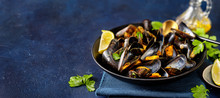 Close Up Of Delicious Steamed Mussels In A Plate On Blue Background