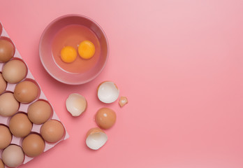 Canvas Print - Eggs in bowl with eggshell on pink background