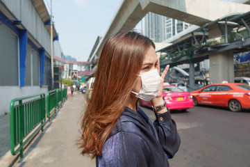 Wall Mural - Beautiful woman wearing anti dust mask protect air pollution and pm 2.5 on street city