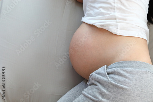 Fotomural mother pregnant resting on bed, image maternity healthy care concept background
