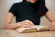 An Asian female student wearing a black shirt sitting and reading at university