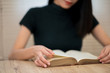An Asian female student wearing a black shirt sitting and reading at university