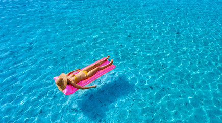 Poster - Woman relaxing on inflatable mat float