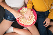 © engagestock - Top View Two Girls Eating Pop Corn From Pink Bowl