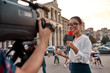 © Svitlana - News that works. TV reporter presenting the news outdoors. Journalism industry, live streaming concept.