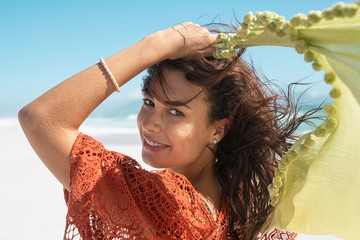 Wall Mural - Happy woman holding scarf at beach