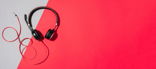 Music and sound concept. Style black headphones on grey and red background. Top view. Copy space. Urban summer time