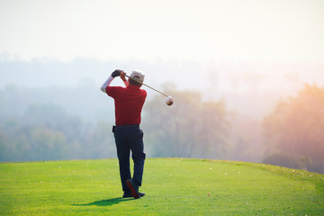 mature man playing golf on a golf course in the summer morning