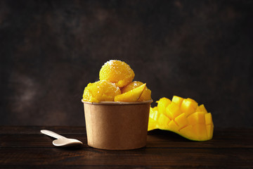 Wall Mural - A paper cup with delicious vegan tropical sorbet on dark background