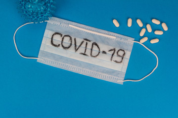 Coronavirus outbreak — Coronavirus 2019 disease, COVID-19, nCoV, WUHAN virus concept on blue background. Image of a blue face protective mask, pills and virus.