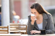 © Antonioguillem - Woman blowing her nose with tissue on a coffee shop