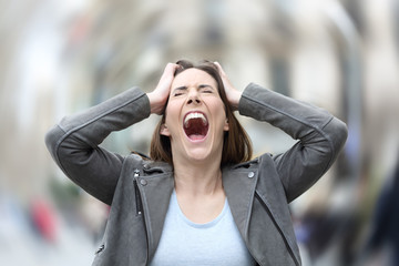 Stressed woman suffering anxiety attack on city street