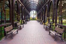 Wooden Archway In An Empty Park. Row Of Benches, Perspective View.