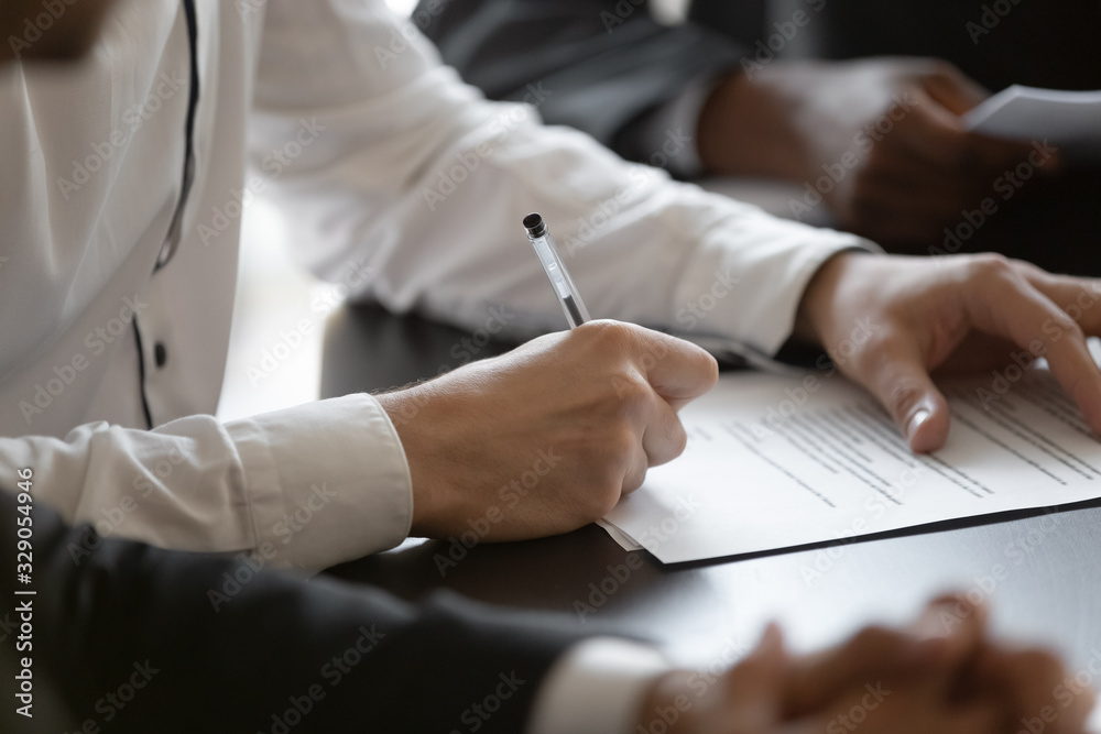 Close up young male employee manager customer hands signing paper contract after checking. Millennial investor client put signature at business agreement between partners. Editor making corrections. - obrazy, fototapety, plakaty 