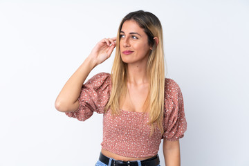 Young Uruguayan woman over isolated white background having doubts and with confuse face expression