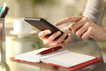 Woman checking phone with agenda over the table