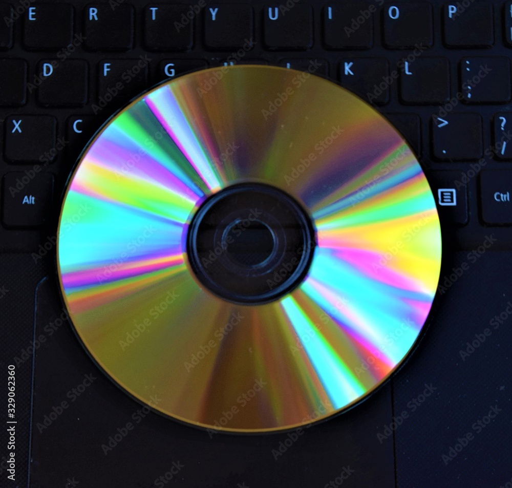 Disc On Computer CD DVD disc on laptop computer keyboard detail Stock Photo | Adobe Stock