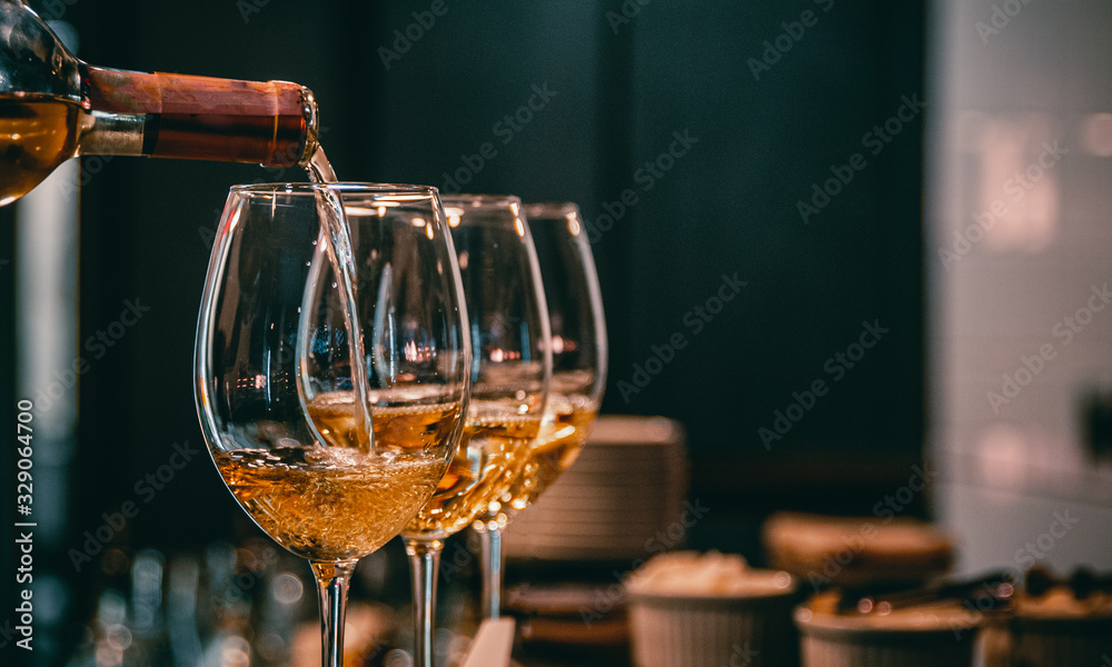 bartender pouring white wine into a glass in cafe or bar - obrazy, fototapety, plakaty 