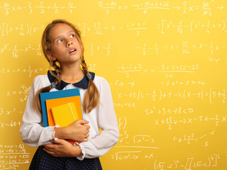 Young student is with shocked expression and think about complex exercises. Yellow background