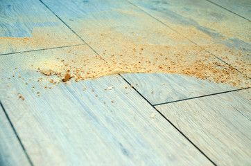 Sawdust and dust on the floor from the laminate before cleaning the room